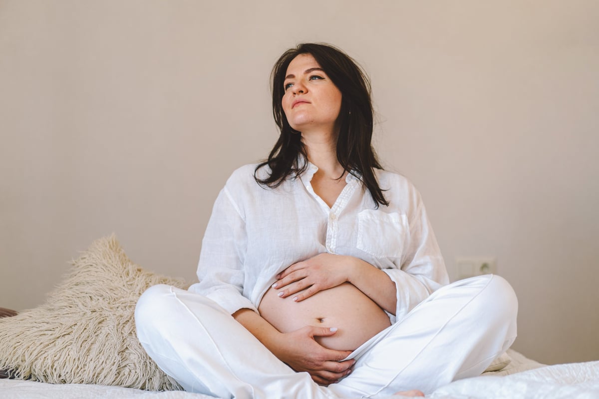 Mujer embarazada descansando y acariciando su abdomen, tranquilidad materna