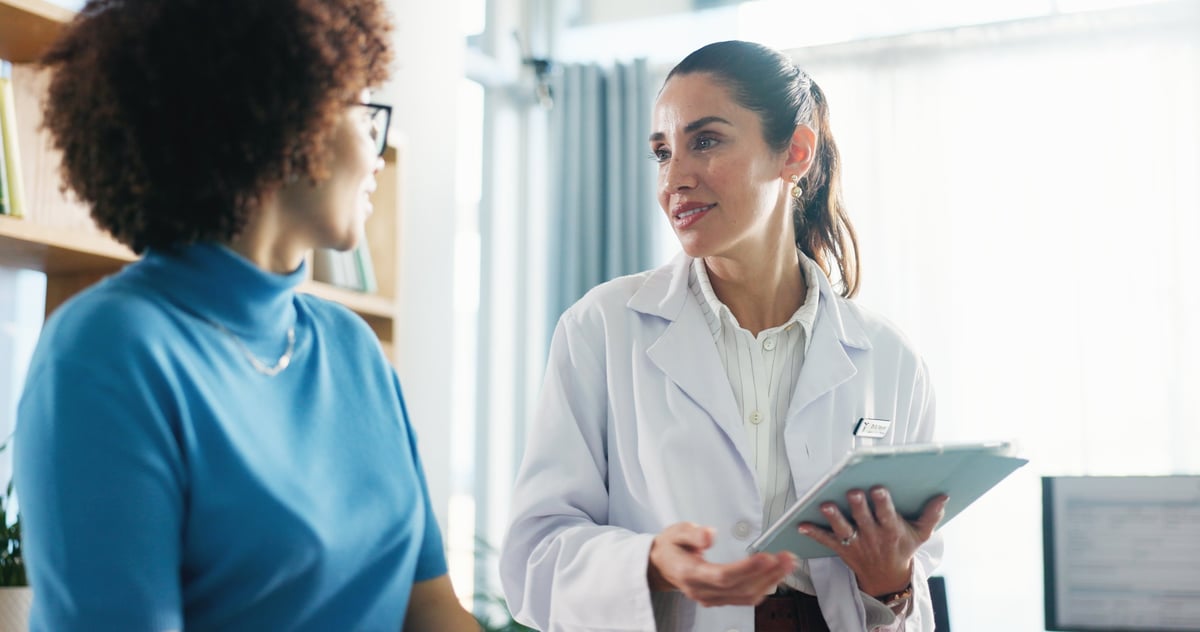 Mujer conversando con su ginecóloga en consultorio, confianza y atención médica femenina